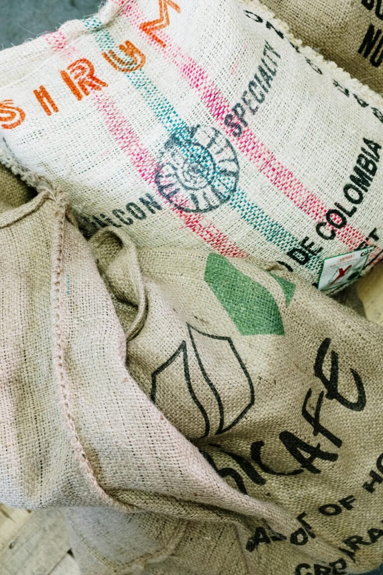 Close-up of burlap sacks for organic coffee beans in a roastery setting.
